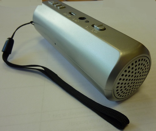 Zegarek z budzikiem z tworzywa sztucznego o kształcie cylindrycznym z paskiem umożliwiającym zawieszenie go na nadgarstku. Po podłączeniu do urządzenia audio może być wykorzystany również jako głośnik do słuchania muzyki. Czas wyświetlany jest na płaskich powierzchniach za pomocą projektora. Posiada przycisk przesuwania, uruchamiania projektora oraz dwa przyciski umożliwiające ustawienie godziny, daty i alarmu budzika. Wyposażony jest również w dwa wejścia: DC 5V i AUX. Produkt posiada baterię Li-ion, która  może być ładowana dzięki przewodowi USB. Wymiary: średnica: ok. 3,5 cm, długość: ok. 11 cm. W skład kompletu wchodzą również kabel USB, kabel audio zakończony wtykami typy Jack, instrukcja obsługi. Produkt jednostkowy pakowany w tekturowy kartonik. Opakowanie zbiorcze stanowią kartony papierowe.
