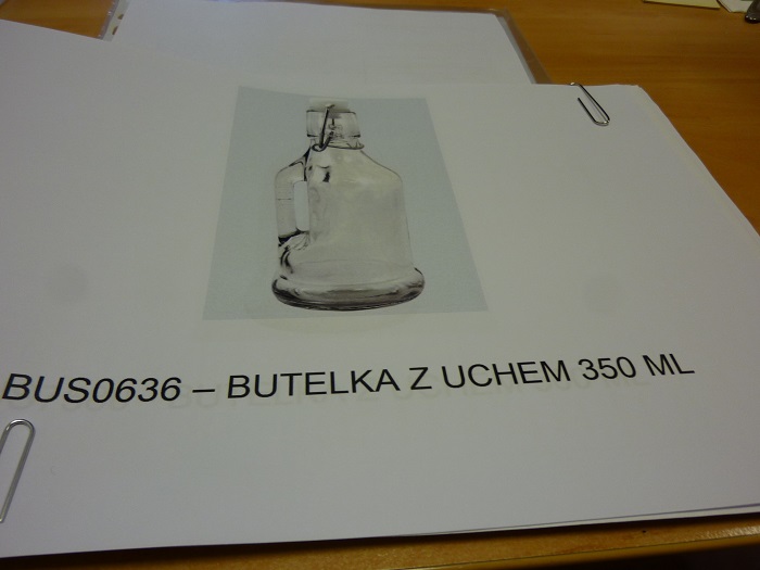 Butelka z zamknięciem typu Weck o zaokrąglonej  podstawie, ze szklanym uchem. Naczynie szklane wykonane z bezbarwnego szkła sodowo-wapniowego. Posiada specjalnie wyprofilowaną krawędź otworu, na którą nakładana jest kolista płaska gumowa uszczelka oraz specjalnie dopasowany wyprofilowany korek. Korek dociskany jest do butelki specjalnie skonstruowaną sprężyną zaczepianą o jej krawędź. Zgodnie z deklaracją Wnioskodawcy wyrób przeznaczony jest na soki, wodę lub inne napoje. Pojemność: 0,350 L, 0,500 L.
