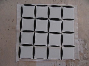 Mozaika wykonana z kostek szklanych, malowanych od spodu. Tafle szkła o grubości 4 mm pocięte na elementy o różnych kształtach i wymiarach 10 x 75 mm (kształt łezki), 75 x 75 mm (kształt kwadratu) umieszczone na podłożu - siatce z tworzywa sztucznego, połączone za pomocą kleju żywicznego - tworząc taflę o wymiarach 314 x 314 mm (±5 mm) o grubości 4 mm. Stosowana jako materiał do wykładania ścian wewnątrz pomieszczeń. Mozaiki występują w różnych wariantach kolorystycznych. Prezentowana w zbiorczym opakowaniu kartonowym po 20 sztuk w kartonie.