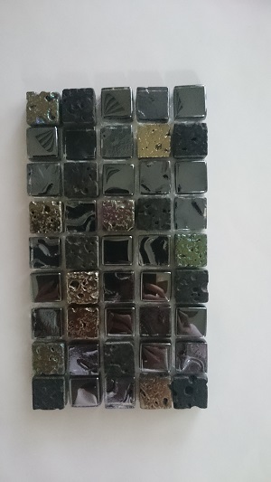 Mozaika wykonana z kostek o wymiarach 14 x 14 x 8 mm. W skład mozaiki wchodzą kostki szklane i kostki kamienne (lawa wulkaniczna). Największą powierzchnię stanowią kostki szklane (ok. 84%) o zaoblonych krawędziach, które od spodu są malowane farbami, z wierzchu są pokrywane metodą galwaniczną. Powierzchnia dekoracyjna części kostek kamiennych jest malowana farbami, a część poddana procesowi galwanizacji. Poszczególne kostki umieszczone są na podłożu - siatce z tworzywa sztucznego, połączone za pomocą kleju żywicznego - tworząc mozaikę o wymiarach 30 x 30 cm, o grubości 0,8 cm. Ilość kostek szklanych i kamiennych jest losowa. Stosowana jako materiał do wykładania ścian wewnątrz pomieszczeń. Prezentowana po 11 szt. w opakowaniu zbiorczym.