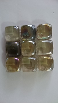 Mozaika wykonana z kostek szklanych wykonanych ze szkła odlewanego, o wymiarach ok. 23 x 23 mm, malowanych od spodu farbą kryjącą. Powierzchnia kostek pokrywana jest farbą iryzującą, a następnie podgrzewana. W wyniku tego zabiegu uzyskuje się przeźroczyste koski o zaokrąglonych brzegach i różnobarwnym kolorze odbicia światła. Tak przygotowane kostki umieszczone na podłożu - siatce z tworzywa sztucznego, połączone za pomocą kleju żywicznego - tworząc taflę o wymiarach 300 x 300 mm (±5 mm) o grubości 14 mm. Stosowana jako materiał do wykładania ścian wewnątrz pomieszczeń. Prezentowana w zbiorczym opakowaniu kartonowym po 7 sztuk w kartonie.