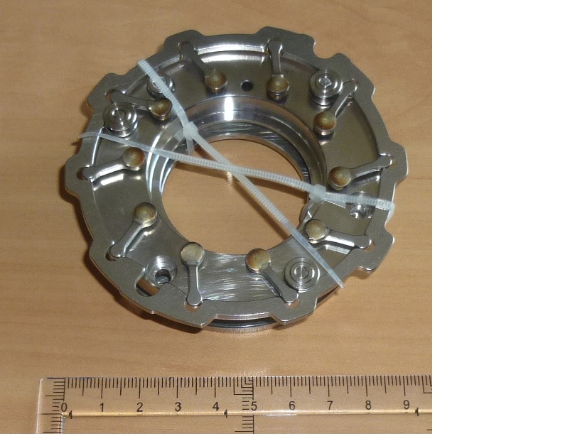 Kierownica spalin o zmiennej geometrii - element wykonany ze stali, w postaci dwóch pierścieni o różnej grubości, położonych współśrodkowo. Pomiędzy pierścieniami znajdują się obwodowo położone łopatki w postaci prostokątnych płytek, zamocowane w sposób dający im możliwość wykonywania ruchu obrotowego w pewnym zakresie. Nad jednym z pierścieni umieszczony jest mechanizm sterujący ruchem obrotowym łopatek. W jednym ze skrajnych położeń mechanizmu, łopatki zamykają prześwit pomiędzy pierścieniami, a w drugim skrajnym położeniu mechanizmu, łopatki otwierają prześwit pomiędzy pierścieniami. Kierownica spalin jest elementem jednostopniowej turbosprężarki stosowanej w silnikach spalinowych w celu doładowania powietrzem cylindrów silnika. Umożliwia kierowanie przepływem spalin silnika na wirnik turbiny.