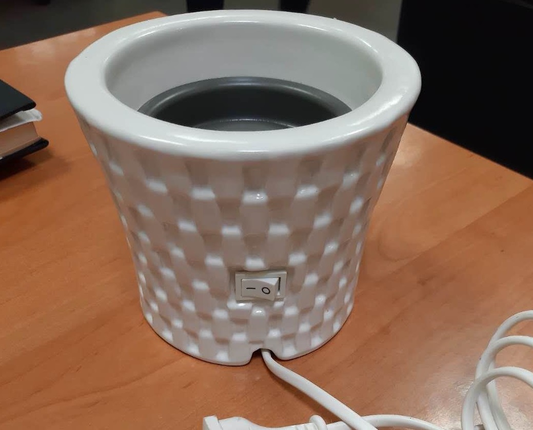 Ceramiczny podgrzewacz przeznaczony do topienia wosku zapachowego. Główne elementy składowe urządzenia to: ceramiczna obudowa,  wewnętrzny element grzejny z przewodem elektrycznym; metalowy wkład do podgrzewania wosku, bezpiecznik termiczny, kabel zasilający i przełączniki. Kapsuła z woskiem zapachowym umieszczana jest w podgrzewaczu, gdzie pod wpływem ciepła wosk rozpuszcza się i uwalnia aromat. Jest to urządzenie elektrotermiczne do użytku domowego. Napięcie zasilania: 100 – 240 V.