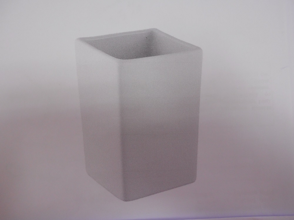 Kubek ceramiczny o podstawie w kształcie kwadratu o wymiarach górnej krawędzi ok. 8,0 cm x 8,0 cm i wysokości ok. 11 cm. Grubość ścianek ok. 4-5 mm (po usunięciu warstwy tworzywa z ceramiki).Wykonany z szarej ceramiki szkliwionej białym szkliwem wewnątrz i na zewnątrz. Zewnętrzna powierzchnia kubka pokryta jest warstwą białego tworzywa (soft-feel). Posiada cechy charakterystyczne dla wyrobu kamionkowego. Przeznaczony do przechowywania akcesoriów łazienkowych, np. wacików, patyczków kosmetycznych, pasty do zębów itp. Produkt wolnostojący bez elementów mocujących. Opakowanie: zbiorcze pudełko kartonowe  (6 szt. w kartonie).