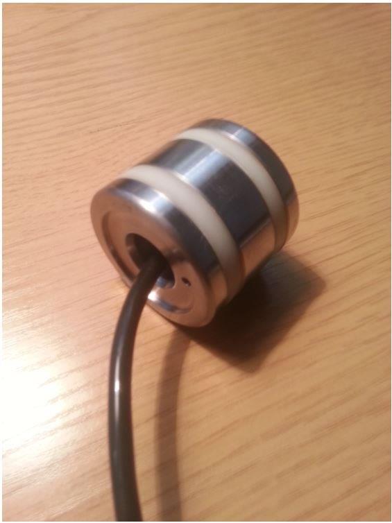 Zespół rdzenia tłoka w postaci elektromagnesu o kształcie walca o średnicy do 4 cm i wysokości do 4 cm. Element jest wykonany z metalu nieszlachetnego i tworzywa sztucznego. Może być wyposażony w elektrycznie izolowany przewód o długości do 50 cm, bez złączki na końcu. Cewka jest przeznaczona jako część składowa do amortyzatora stosowanego w osobowych pojazdach samochodowych. Jej zadaniem jest wytwarzanie pola magnetycznego, które zmieniając właściwości fizyczne płynu wypełniającego amortyzator, zmienia jego siły tłumienia.