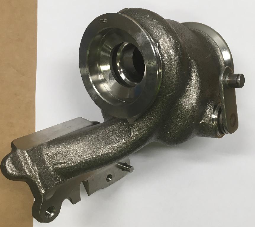 Korpus turbiny turbosprężarki, w kształcie nieregularnego odlewu o wymiarach około 163x116x113 mm. Korpus składa się z obszaru wlotu i wylotu spalin, woluty oraz wirnika turbiny o średnicy 31 mm. Korpus wykonany jest ze stali żaroodpornej na bazie chromu i niklu, odpornej na działanie wysokich temperatur - maksymalna temperatura pracy materiału wynosi 1000 stopni C. Ponadto w skład korpusu wchodzą: zawór wahadłowy – 1 szt. (materiał: stal żaroodporna), wałek regulacyjny – 1 szt. (materiał: stal żaroodporna), podkładka – 1 szt. (materiał: stal żarowytrzymała), sprężyna talerzowa - 2 szt. (materiał: stal żarowytrzymała), kołek ustalający – 1 szt. (materiał: stal nierdzewna), tuleja –  1szt. (materiał: stal żaroodporna), sworzeń – 2 szt. (materiał: stal nierdzewna), dźwignia regulacyjna – 1 szt. (materiał: stal nierdzewna). Zadaniem korpusu jest kierowanie gazów wydechowych z silnika spalinowego na wirnik turbiny, a następnie orientowanie tych gazów do układu wydechowego w pojeździe. Korpus pełni również funkcję ochronną przed czynnikami zewnętrznymi. Celem kołka ustalającego jest prawidłowe spozycjonowanie korpusu turbiny w zespole turbosprężarki.