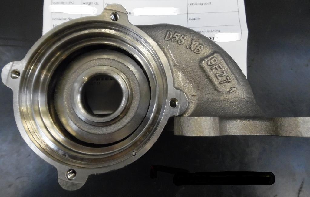 Korpus turbiny turbosprężarki, w kształcie nieregularnego odlewu o wymiarach około 192x125x115 mm. Korpus składa się z obszaru wlotu i wylotu spalin, woluty oraz wirnika turbiny o średnicy 35 mm. Korpus wykonany jest z żeliwa austenitycznego z wysoką zawartością niklu, odpornego na działanie wysokich temperatur - maksymalna temperatura pracy materiału wynosi 950 stopni C. Ponadto w skład korpusu wchodzą: kołek ustalający – 1 szt. (materiał: stal nierdzewna), wkładka gwintowa – 2 szt. (materiał: stop niklowo chromowy). Zadaniem korpusu jest kierowanie gazów wydechowych z silnika spalinowego na wirnik turbiny, a następnie orientowanie tych gazów do układu wydechowego w pojeździe. Korpus pełni również funkcję ochronną przed czynnikami zewnętrznymi. Celem kołka ustalającego jest prawidłowe spozycjonowanie korpusu turbiny w zespole turbosprężarki.