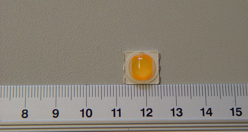 Diody świecące (LED), o wymiarach 12,4 x 11,4 x 4,38 mm, emitujące światło barwy ciepło białej. Zapakowane po 800 sztuk, na taśmie z tworzywa sztucznego o szerokości 24 mm, która nawinięta jest na szpulę o średnicy 13". Diody nie posiadają żadnych dodatkowych elementów, przeznaczone są do montażu powierzchniowego SMD. Napięcie zasilania: 100 - 120 V / 58 mA oraz 220 - 240 / 29 mA.