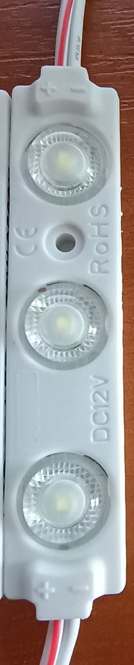 Elementy oświetleniowe w postaci modułów LED. Każdy moduł zawiera trzy diody LED montowane powierzchniowo na płytce PCB wraz układem wyrównującym napięcie. Produkty posiadają szczelną, wodoodporną obudowę z tworzywa sztucznego, podklejoną od spodu taśmą 3M. Na obu końcach wyposażone zostały w przewody elektryczne, które umożliwiają łączenie modułów w łańcuchy i/lub podłączenie do zasilacza (niebędącego przedmiotem niniejszej decyzji). Produkt stosowany jest do podświetlenia mebli, sufitów, schodów, wnętrza samochodów, itp. Zasilanie 12 VDC, pobór mocy: 1,2 W. Wymiary modułu (w mm): 71 x 15 x 8. Produkt pakowany jest w łańcuchach po 30 szt, następnie w torebki foliowe po 120 szt i kartony - 960/1920 sztuk.