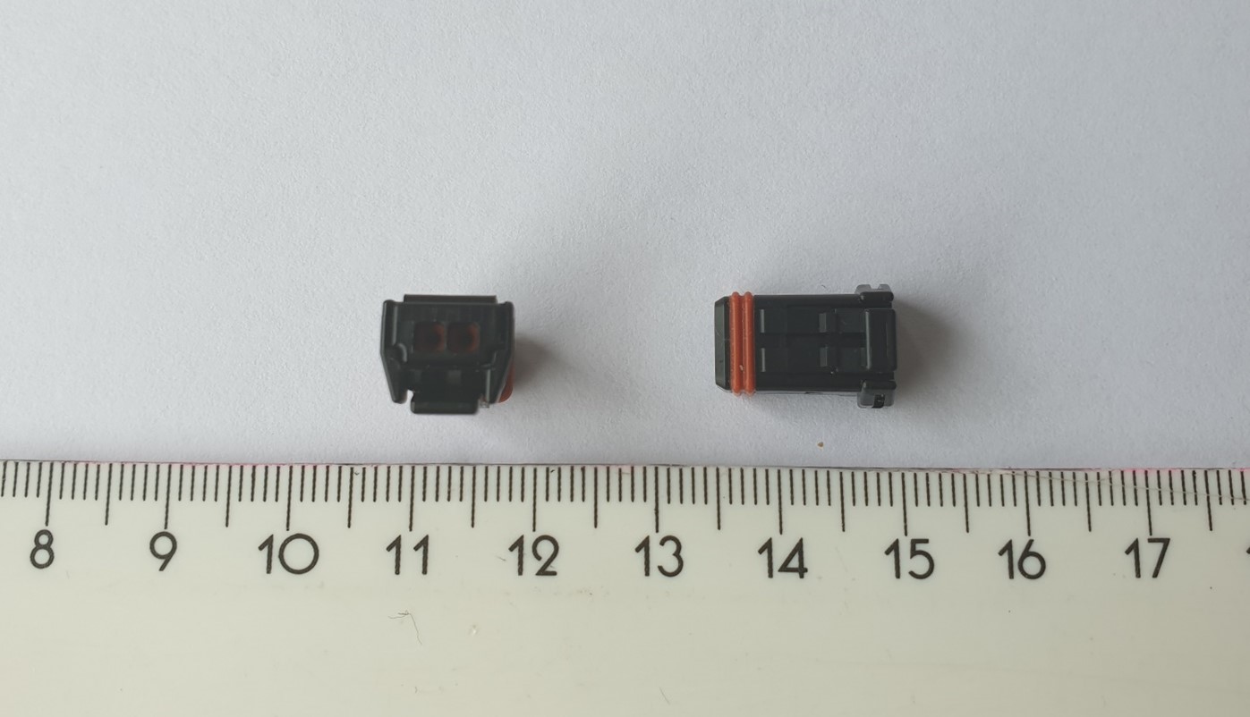 Korpus (obudowa) złącza elektrycznego. Specjalnie ukształtowany, izolacyjny korpus wykonany z tworzywa sztucznego (PBT) z dwoma małymi otworami i uszczelnieniem. Produkt nie zawiera metalowych styków, końcówek lub żadnych innych materiałów przewodzących prąd elektryczny. Terminale (styki lub kontakty) wiązki przewodzącej wkładane są do oddzielnych otworów korpusu podczas montażu złącza elektrycznego, dzięki czemu produkt zabezpiecza, izoluje od siebie styki przewodzące i zapobiega zwarciom. Stosowany do montażu kabli o średnicy 1,4 -1,7 mm. Przybliżone wymiary korpusu: 9,8 mm x 14,1 mm x 7,65 mm.
WIT wydana powtórnie w miejsce decyzji nr PL BTI WIT-2023-000168 z dnia 03.02.2023 r.