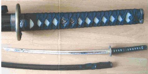 "Katana" - imitacja miecza samurajskiego (wersja ostra). Ostrze wykonane jest ze stali nierdzewnej i nie jest hartowane. Rękojeść z tworzywa sztucznego, owinięta taśmą. Wyrób przeznaczony jest do celów dekoracyjnych. Długość 1,03 m. Masa 1,1 kg.