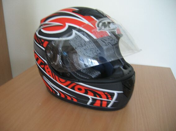 Kask motocyklowy (integralny) wykonany z tworzywa sztucznego (ABS), wyłożony wewnątrz warstwami styropianu, pianki amortyzującej i dzianiną. Kask posiada ruchomą, wykonaną z poliwęglanu szybkę oraz pasek podbródkowy zapinany przy pomocy metalowej lub wykonanej z tworzywa sztucznego sprzączki. Produkt zapakowany w wykonany z włókniny worek i pudełko kartonowe.
Dostępne rozmiary: od XS (53-54 cm) do XXL (63-64 cm).