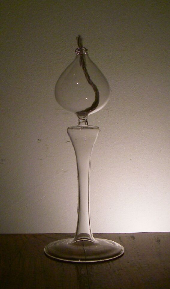 Nieelektryczna lampka na paliwo płynne. Wykonana ze szkła borokrzemowego, niebarwionego. Wymiary: ok. 5 cm x 19 cm x 7cm. Pojemność 60 ml. Prezentowana w jednostkowym kartonowym opakowaniu razem z trzema knotami.