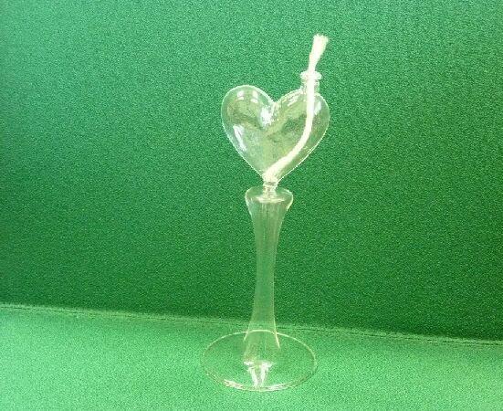 Nieelektryczna lampka na paliwo płynne. Wykonana ze szkła borokrzemowego, niebarwionego, z pojemnikiem na płyn w kształcie serca. Wymiary: ok. 19 x 7 cm. Pojemność 60 ml. Prezentowana w jednostkowym kartonowym opakowaniu razem z trzema knotami.