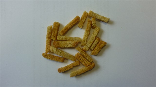 Produkt o smaku bekonu, otrzymany z pokrojonego (wysuszonego) chleba pszenno-żytniego,  w postaci cienkich nieregularnych patyczków różnej długości (o wym. ca: 0,4 cm x 0,5 cm x 4 cm), poddany procesowi opiekania z olejem słonecznikowym i mieszania z dodatkami smakowo-aromatyzującymi. Produkt zawiera w składzie m.in.: mąkę pszenną, mąkę żytnią, drożdże, sól, wodę, olej słonecznikowy, ekstrakt z papryki, glutaminian sodu E 621.
Opakowanie jednostkowe o wadze netto 35 g.