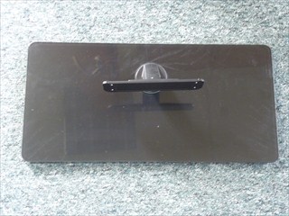 Podstawa odbiornika telewizyjnego, wykonana ze szkła hartowanego z topionej krzemionki oraz ze stopu aluminium. Dolna część, w kształcie prostokąta o wymiarach 484 x 240 mm, składa się z dwóch warstw. Wierzchnia część wykonana jest z hartowanego szkła z topionej krzemionki, natomiast część spodnia z aluminium. Obie warstwy skręcone są wkrętami ze stali nierdzewnej. Podstawa połączona jest ze statywem o wysokości 113 mm, sporządzonym ze stopu aluminium, umożliwiającym zamontowanie odbiornika telewizyjnego. Stopa telewizora wyposażona jest w podkładki antypoślizgowe, taśmę dwustronną, naklejkę i folię ochronną. Produkt przeznaczony jest do stabilizacji odbiornika telewizyjnego na płaskiej powierzchni.