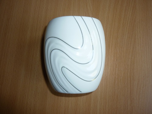Kubek kosmetyczny o średnicy przy górnej krawędzi ok. 8 cm, średnicy podstawy ok. 4,5 cm  i wysokości ok. 10,2 cm, wykonany z ceramiki w kolorze białym, szkliwiony. Ścianki kubka posiadają zdobienia w postaci wytłoczeń w kształcie muszelek i rozgwiazdy w kolorze srebrnym. Produkt o cechach charakterystycznych dla porcelany. Kubek przeznaczony do przechowywania akcesoriów łazienkowych, np. wacików, patyczków kosmetycznych.