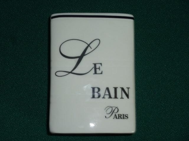Kubek kosmetyczny biały, bez ucha wykonany z porcelany, szkliwiony białym szkliwem. Po jednej stronie kubka znajduje się czarny napis "LE BAIN PARIS". Kubek przeznaczony do przechowywania akcesoriów łazienkowych (np. pasty do zębów,szczoteczek). Pakowany w jednostkowym pudełku kartonowym. Wymiary: podstawa w kształcie prostokąta o wym. ok. 4,7 cm x 7,8 cm, Wysokość ok.  10,9 cm.