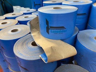 Fita Papel Ráfia VCI579 51x150x240mm, composta por dois elementos: papel kraft com densidade de 70gr/m2, impregnado com protetor químico VCI579 6gr/m2, e ráfia laminada cor azul, impressa com o logótipo e a palavra Lusosider em azul contrastante com o azul de fundo.

A Fita Papel Ráfia é apresentada em rolos, os quais medem 15 cm de largura.
O papel kraft é fabricado com 100% de celulose fibra longa virgem, a qual é obtida através do processo de polpação química do sulfato.
A Fita Papel Ráfia é utilizada na embalagem de materiais metálicos, mais concretamente, nas bobines de chapa galvanizada, produzidas pela requerente, com vista a garantir a sua proteção contra a corrosão verificada nos processos de armazenagem e transporte.

O papel kraft encontrar-se impregnado com um protetor químico (VCI - Inibidor Volátil de Corrosão)que impede a oxidação do material metálico embalado, absorvendo a humidade.

Por sua vez, a ráfia permite um melhor ajustamento do papel ao produto embalado, limitando-se a proteger a chapa galvanizada de riscos superficiais resultantes de eventuais choques.
Atendendo a que a função do papel Kraft consiste na proteção da chapa galvanizada contra a corrosão, o papel kraft assume uma importância primordial face à ráfia, afigurando-se ser esta última (a ráfia) um elemento meramente acessório no processo de embalagem.