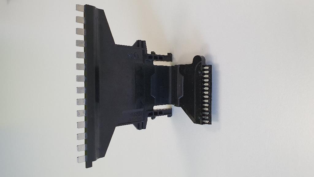 Produsul reprezintă un ansamblu format din conductori de cupru inglobati prin turnare intr-un invelis de material plastic si elastomer(cauciuc), denumit cadru conector pentru bobina electrica.
Componenta este proiectata sa asigure transmiterea semnalelor electrice către unitatea centrala de control a modulul electronic de control al cutiei automate de viteze şi catre diferitele unitati de actionare electrica (solenoizi, pompa electrica) ale cutiei de viteze. Ansamblul este o componenta pasiva a modulului electronic de control al cutiei automate de viteza care realizeaza doar conexiunea electrica dintre diferitele subansamble ale modulului, fiind o parte a acestuia.
Conductorii sunt proiectati pentru transmiterea unui semnal electric cu tensiunea maxima de 30 V.C.C si 3 A. Marfa vine ambalata pe palet de lemn in cutii de carton avand in interiorul fiecarui cutii cate 84 de buc.