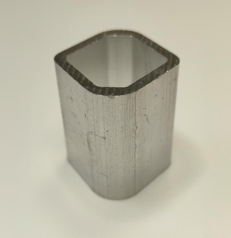 Produsul reprezintă o piesă metalică de formă paralelipipedică, rotunjită la colţuri, cu o sectiune hexagonală goală la interior. Este fabricată din aliaj de aluminiu EN AW-6061 T6 DIN EN 755-2.
Reprezintă o parte a unei piese de tip “bucşă” cu rol antivibraţii (AVS – “anti vibration system”) ȋn cadrul sistemului de suspensie al unui autovehicul și care asigură partea care preia vibraţiile/şocurile, ȋn general ȋntre elemente de caroserie şi compartimentul motor.
Caracteristici: ȋnălţimea de 44 mm, suprafaţa ȋn vedere frontală are lungimea 40 mm şi laţimea 39.5 mm, suprafaţa in vedere frontală gol interior hexagonal are următoarele dimensiuni 31x26x26 mm. 
Procesul tehnologic de obţinere a piesei este cel de extrudare a profilului de aluminiu, tăiere (debitare la lungime).
Ulterior punerii in libera circulatie, asupra piesei se intervine cu tratamente chimice (adezivare) care asigură curăţarea de impurităţi ȋn vederea asigurării aderenţei necesare aplicării unui strat de cauciuc.