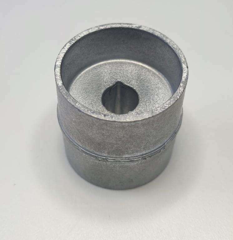 Produsul reprezintă o piesă metalică de formă cilindrică prevazută cu o nervura transversală, cu o sectiune cilindrică goala la interior, din aliaj de aluminiu EN AC-44300 DIN EN 1706.
Reprezintă o parte a unei piese de tip “bucşă” cu rol antivibraţii (AVS – “anti vibration system”) ȋn cadrul sistemului de suspensie al unui autovehicul și care asigură partea care preia vibraţiile/şocurile, ȋn general ȋntre elemente de caroserie şi compartimentul motor.
Caracteristici: ȋnălţimea de 50.75 mm, suprafaţa ȋn vedere frontală are lungimea de 49 mm şi lăţimea 47 mm, diametru interior cu geometrie specifică de poziţionare (ȋn formă de lacrimă) de Ø 14 mm. La unul din capete piesa metalică are un locaş frezat cu următoarele caracteristici: suprafaţa in vedere frontală are lungimea 41.3 mm şi lăţimea 39.3 mm şi adâncime de 18 mm.
Procesul tehnologic de obţinere a piesei este cel de extrudare a profilului de aluminiu, tăiere (debitare la lungime) şi prelucrare prin aşchiere a locaşului.
Ulterior punerii in libera circulatie, asupra piesei se intervine cu tratamente chimice (adezivare) care asigură curăţarea de impurităţi ȋn vederea asigurării aderenţei necesare aplicării unui strat de cauciuc.