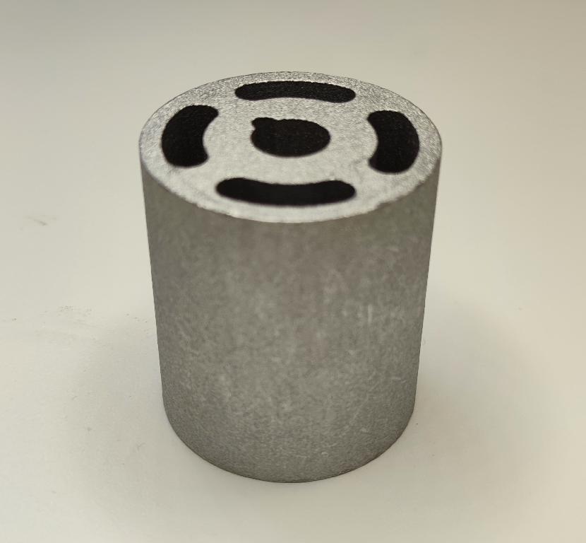 Produsul reprezintă o piesă metalică de formă cilindrică, cu o sectiune cilindrică goala la interior, din aliaj de aluminiu EN AW-6082 T6.
Reprezintă o parte a unei piese de tip “bucşă” cu rol antivibraţii (AVS – “anti vibration system”) ȋn cadrul sistemului de suspensie al unui autovehicul și care asigură partea care preia vibraţiile/şocurile, ȋn general ȋntre elemente de caroserie şi compartimentul motor.
Caracteristici: ȋnălţimea de 60 mm, suprafaţa ȋn vedere frontală are lungimea 53 mm, diametru interior cu geometrie specifică de poziţionare (ȋn formă de lacrimă) de 14.1 mm. 
Procesul tehnologic de obţinere a piesei este cel de extrudare a profilului de aluminiu, tăiere (debitare la lungime) şi prelucrare prin aşchiere a locaşului.
Ulterior punerii in libera circulatie, asupra piesei se intervine cu tratamente chimice (adezivare) care asigură curăţarea de impurităţi ȋn vederea asigurării aderenţei necesare aplicării unui strat de cauciuc.