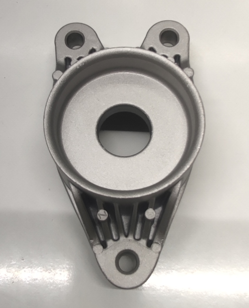 Produsul reprezintă o piesă metalică de formă cilindrică, cu o sectiune cilindrică goala la interior, din aliaj de aluminiu EN AC-44300 DIN EN 1706.
Reprezintă o parte a unei piese de tip “ansamblu” cu rol antivibraţii (AVS – “anti vibration system”) ȋn cadrul sistemului de suspensie al unui autovehicul și care asigură partea care preia vibraţiile/şocurile, ȋn general între elemente de caroserie şi amortizorul spate.
Caracteristici: ȋnălţimea de 59.8 mm, suprafaţa ȋn vedere frontală are lungimea 148 mm şi laţimea 78 mm. Piesa metalică este prevăzută cu trei urechi care au următoarele caracteristici: locaş frezat cu diametrul Ø9 mm, respectiv Ø10 mm pe toată grosimea materialului.  
Procesul tehnologic de obţinere a piesei este cel de turnare a aluminiului ȋn lingotiere, debitare şi prelucrare prin aşchiere a locaşului.