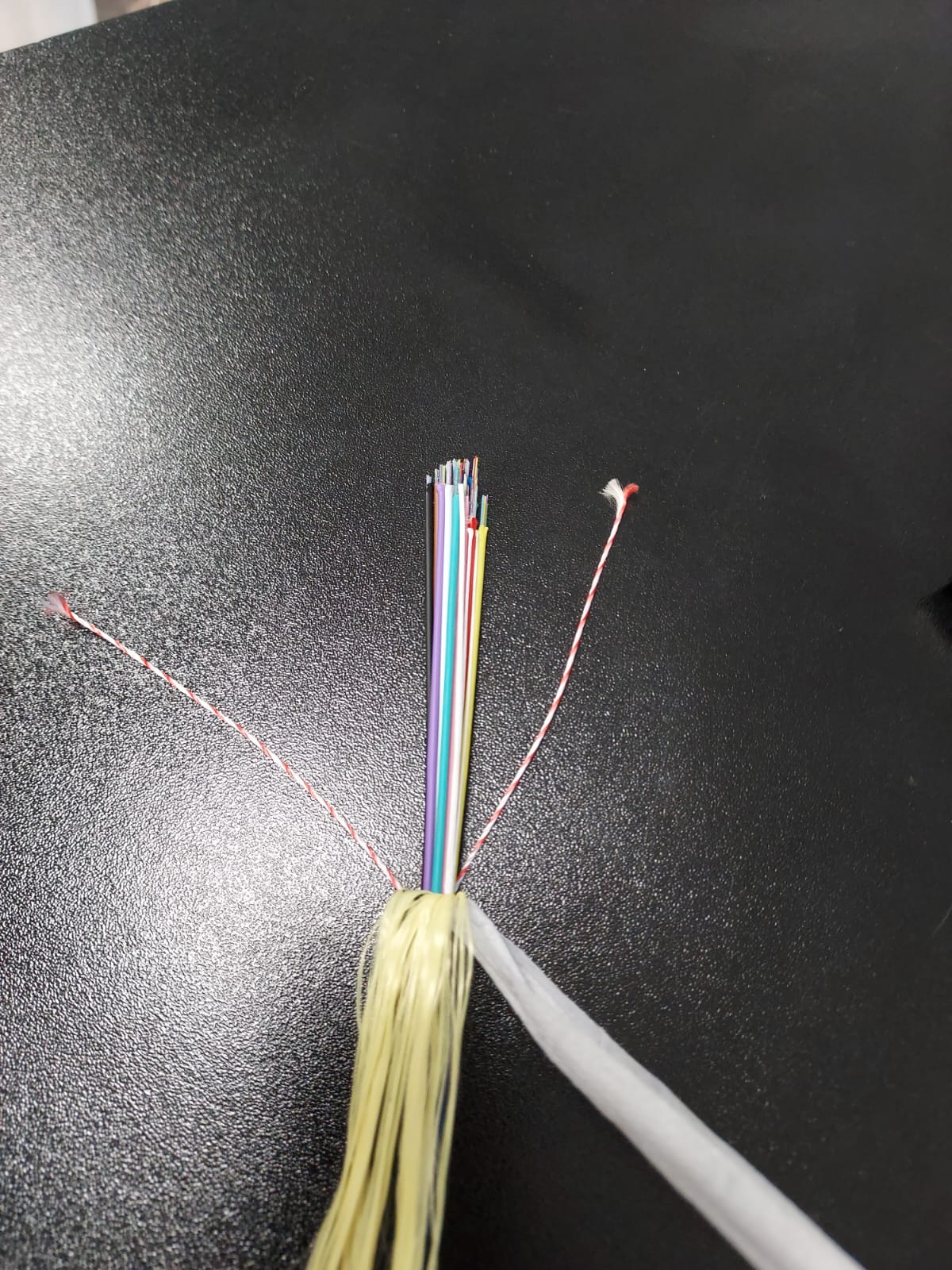 Produsul reprezinta un cablu de comunicatie de tip FTYM care contine 24, 48, 96 sau 144 fibre optice de 125um, neizolate individual. Este un cablu cu sectiunea de aproximativ 7-12 mm, de culoare neagra. Produsul este compus astfel: fibre optice grupate intr-o izolatie comuna, fibre de plastic FRP, tesatura din fibra de sticla (glass yarn), PBT (Polibutilena tereftalat), gel, tuburi libere, compus de umplere (filling compound), camasa exterioara din polietilena HDPE. Cablul se utilizeaza pentru transmiterea de informatii (imagini, sunete, date, etc.) folosind lumina care este trasmisa pe mai multe lungimi de unda in interiorul fibrelor optice. Cablul este rulat pe tambur din lemn.