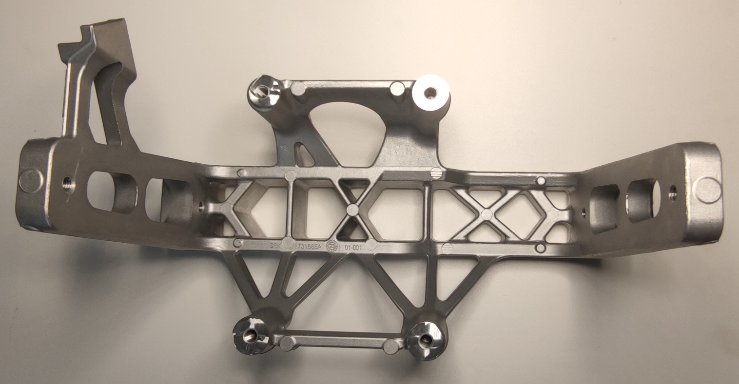 Conform descrierii solicitantului și a fotografiei publicate în baza de date, produsul reprezintă o piesă metalică de formă paralelipipedică, cu o secţiune longitudinală goală la interior. Este fabricată din aliaj de aluminiu Caracteristici: ȋnălţimea de 181 mm, suprafaţa ȋn vedere frontală are lungimea 311.38 mm şi laţimea 200.25 mm. Piesa metalică are multiple locaşe frezate cu diametrul M8 şi adâncime de 22 mm, respectiv pe toată grosimea piesei. 
Procesul tehnologic de obţinere a piesei din aliaj de aluminiu constă în turnarea aliajului de aluminiu in lingotiera, debavurarea şi prelucrarea prin aşchiere a locaşelor.
Piesa importată reprezintă o componentă a piesei antivibraţii tip “ansamblu” utilizată ȋn sistemele de amortizare a vibraţiilor/şocurilor, ȋn speţă această componentă auto tip “ansamblu” asigură partea “elastică” care preia vibraţiile/şocurile ȋntre două componente auto rigide.