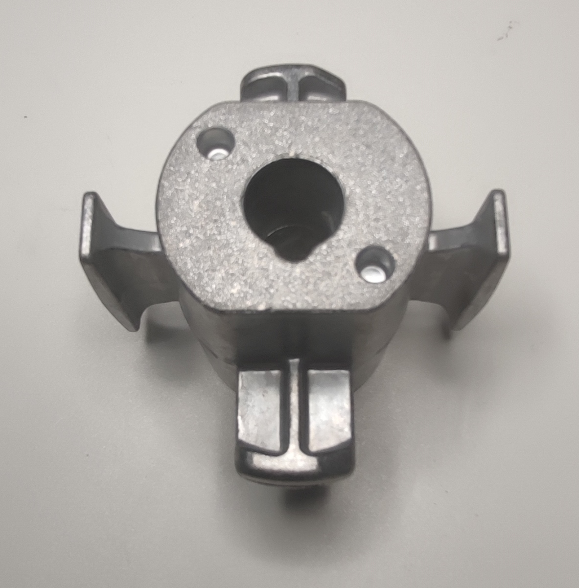 Conform descrierii solicitantului și a fotografiei publicate în baza de date, produsul reprezintă o piesă metalică de formă cilindrică prevazută cu 4 nervuri longitudinale la exterior, cu o sectiune goală la interior, din aliaj de aluminiu EN AC-44300 DIN EN 1706, prelucrat, cu următoarele caracteristici: ȋnălţimea de 71 mm, suprafaţa ȋn vedere frontală are lungimea de 91.1 mm şi lăţimea 81 mm, interior cu geometrie specifică de poziţionare (ȋn formă de lacrimă) cu diametrul de Ø14.2 mm. 
	Procesul tehnologic de obţinere a piesei din aliaj de aluminiu importată de SC Sumiriko AVS Romania este cel de turnare ȋn forme metalice, tăiere (debitare la lungime) şi prelucrare prin aşchiere a locaşului.
	Piesa importată reprezintă componentă esenţială a piesei antivibraţii tip “ansamblu” utilizată de constructorii auto ȋn sistemele de amortizare a vibraţiilor/şocurilor, ȋn speţă această componentă auto tip “ansamblu” asigură partea “elastică” care preia vibraţiile/şocurile ȋntre două componente auto rigide, ȋn general ȋntre elemente de caroserie şi punte spate. Ȋn România asupra piesei se intervine exclusiv cu tratamente chimice (adezivare) care asigură curăţarea de impurităţi ȋn vederea asigurării aderenţei necesare aplicării unui strat de cauciuc. După prelucrare rezultă un produs finit.
	Anterior importului, piesa suportă prelucrări tehnologice şi constructive definitive, respectiv este prelucrată la caracteristicile tehnice şi constructive pentru montarea ȋn produsul finit (lungime, grosime, dimensiuni exterioare, diametru interior, duritate, rugozitate, etc.).