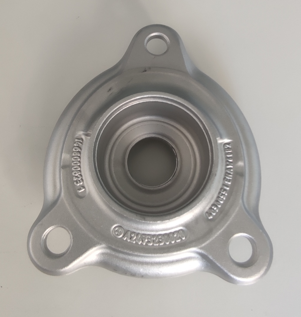 Conform descrierii solicitantului și a fotografiei publicate în baza de date, produsul reprezintă o piesă metalică, cu o secţiune longitudinală plină la interior, din aliaj de aluminiu EN AW 6082 T6 DIN EN 586-2, prelucrată.
Caracteristici: ȋnălţimea de 56.3 mm, suprafaţa ȋn vedere frontală are lungimea 165.5 mm şi lăţimea 142.58 mm. La mijloc produsul are un locaş frezat cu diametrul Ø32 mm pe toată grosimea piesei. De asemenea produsul are trei găuri de fixare cu diametrul Ø14.4 mm. 
Procesul tehnologic de obţinere a piesei din aliaj de aluminiu este cel de forjare, debitare şi prelucrare prin aşchiere a locaşului.
Piesa importată reprezintă componentă esenţială a piesei antivibraţii tip “ansamblu” utilizată de constructorii auto ȋn sistemele de amortizare a vibraţiilor/şocurilor, ȋn speţă această componentă auto tip “ansamblu” asigură partea “elastică” care preia vibraţiile/şocurile ȋntre două componente auto rigide, ȋntre elemente de caroserie şi puntea faţă.
După punerea ȋn libera  circulaţie, aceste piese sunt supuse ȋn România următorului proces tehnologic: sertizare piuliţe in găurile de fixare, introducere ansamblu vulcanizată şi roluire capac pe piesă. După prelucrare rezultă un produs finit conform imaginilor alăturate.
Anterior importului, piesa suportă prelucrări tehnologice şi constructive definitive, respectiv este prelucrată la caracteristicile tehnice şi constructive pentru montarea ȋn produsul finit (lungime, grosime, dimensiuni exterioare, diametru interior, duritate, rugozitate, etc.), fapt ce face ca ȋn România, ulterior importului, să nu necesite alte prelucrări care să ȋi schimbe aceste caracteristici tehnice şi constructive.