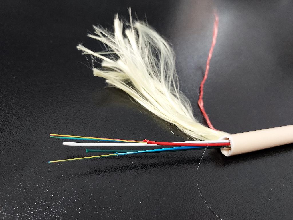 Produsul reprezinta un cablu de comunicatie care contine 6, 24, 32 sau 48 fibre optice de 125um, neizolate individual. Este un cablu cu sectiunea de 7-12 mm, de culoare ivory sau neagra. Produsul este compus astfel: fibre optice grupate intr-o izolatie comuna, tesatura din fibra de sticla (glass yarn) sau fibre de aramida(aramid yarn), PBT (Polibutilena tereftalat), gel, compus de umplere (filling compound), fir de rupere (ripcord), camasa exterioara din polietilena HDPE sau material termoplastic LSZH. Cablul se utilizeaza pentru transmiterea de informatii (imagini, sunete, date, etc.) folosind lumina care este trasmisa pe mai multe lungimi de unda in interiorul fibrelor optice. Cablul este rulat pe tambur din lemn.