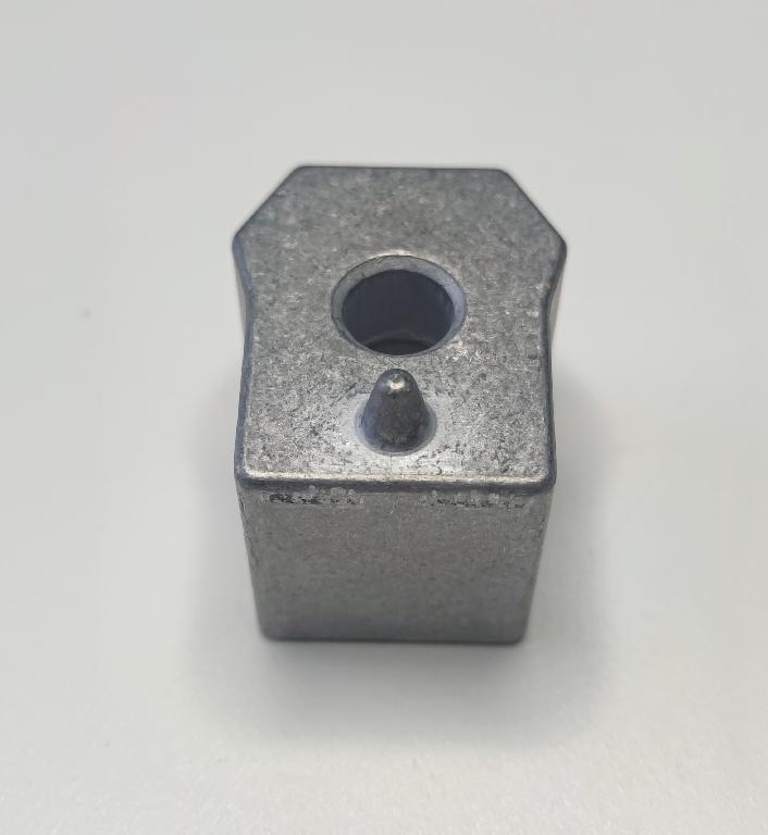 Conform descrierii solicitantului si imaginilor încărcate în baza de date, produsul reprezintă o piesă metalică din aliaj de aluminiu EN AC-44300 (DIN EN 1706), de formă paralelipipedică, cu un locaș interior. Procesul tehnologic de obţinere a piesei cuprinde operațiuni de turnare, debitare şi prelucrare prin aşchiere a locaşului, conform specificațiilor tehnice ale producătorului auto.
Caracteristici dimensionale:
- înălțime: 28 mm
- lungime (față frontală): 36 mm
- lățime: 29,5 mm
- diametru interior: Ø 9 mm
- locaș frezat: Ø 18 mm, adâncime 5 mm.
Aceasta reprezintă o parte a piesei antivibraţii tip “ansamblu” utilizată de constructorii auto ȋn sistemele de amortizare a vibraţiilor/şocurilor, ȋn speţă această componentă auto tip “ansamblu” asigură partea “elastică” care preia vibraţiile/şocurile ȋntre două componente auto rigide, ȋn general ȋntre elemente de caroserie şi compresorul climatizării.
După punerea în liberă circulație, asupra piesei se intervine exclusiv cu tratamente chimice (adezivare) care asigură curăţarea de impurităţi ȋn vederea asigurării aderenţei necesare aplicării unui strat de cauciuc.