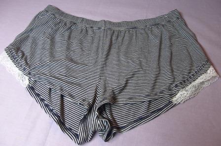 Shorts
Randig byxa med korta ben (shorts) avsedd för kvinnor eller flickor. Byxan är konfektionerad genom sömnad av dukvara av trikå (95 % viskos och 5 % elastan), har resår i midjan, infälld spets nedtill i vardera sida och fållade benslut. Byxan saknar fickor och öppning under midjan.