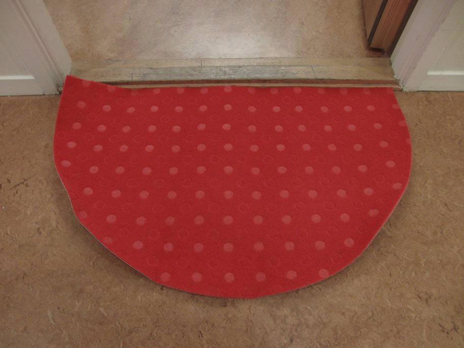 Dörrmatta
Golvbeläggning i form av en halvmåneformad matta med måtten 50 x 80 cm (H x B). Mattans ovansida består enligt uppgift av filt (nålfilt) tillverkad av syntetiska textilfibrer av polypropen (polypropylen). Mattans undersida är enligt uppgift belagd med 50% syntetisk latex och 50% naturlig latex (gummi).