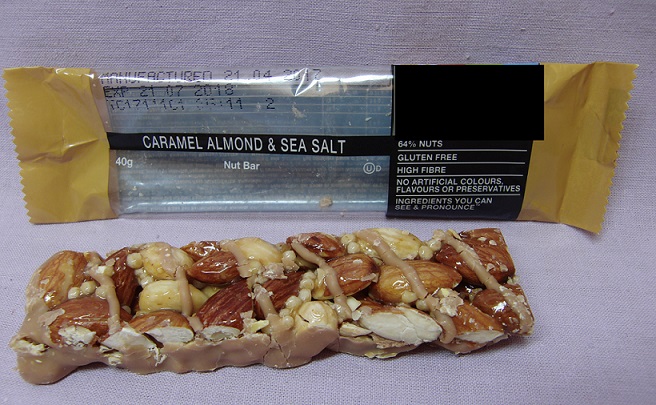 Mandelbar
Livsmedelsberedning i form av en mandelbar (stång), enligt uppgift innehållande  rostade mandlar, karamelliserad smaksättning (cikoriarot, palmkärnsolja, socker, fettfritt mjölkpulver, johannesbrödspulver, havssalt, naturligt aromämne, sojalecitin, färgämne), cikoriarot, honung, glukossirap, rismjöl, emulgeringsmedel (sojalecitin) och socker. Produkten föreligger i detaljhandelsförpackning och väger 40 gram.