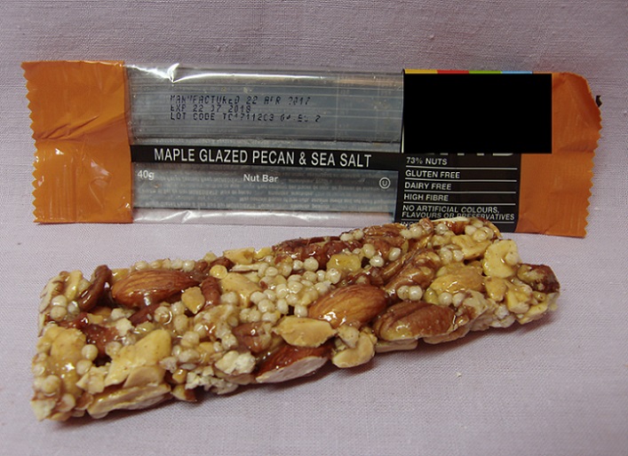 Pekannötsbar smaksatt med lönnsirap.
Livsmedelsberedning i form av en bar (stång), enligt uppgift innehållande en blandning av rostade pekannötter/mandlar/jordnötter, cikoriarot, honung, glukossirap, rismjöl, lönnsirap, havssalt, naturliga aromämnen, emulgeringsmedel och socker. Produkten föreligger i detaljhandelsförpackning och väger 40 gram.