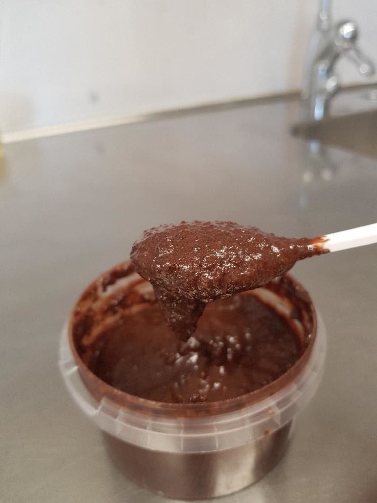 Livsmedelsberedning i trögflytande form, enligt uppgift innehållande vegetabiliskt fett, socker, brunt socker, havregryn, kokosmassa, kakao, vatten, sorbitolsirap, risstärkelse, emulgeringsmedel, naturlig arom, salt och smakämnen. Beredningen är avsedd att användas som smaksättning vid framställning av glass och föreligger i hink om 16 kilo.