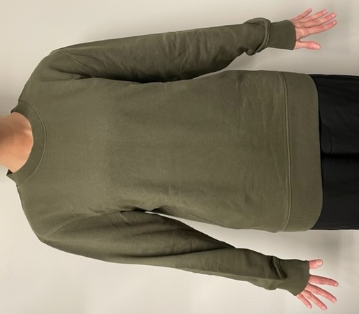 Långärmat ofodrat plagg för överdelen av kroppen i form av en enfärgad tröja (sweatshirt). Plagget är konfektionerat genom sömnad, har rund halsringning (saknar öppning och tillslutning), når ner till strax under midjan och är enligt uppgift avsett för män. Nederkanten av tröjan, halsringningen och ärmsluten är försedda med avsmalnande hopdragning i form av påsydda ribbstickade muddar.
Plagget är inte igenkännlig som en tröja för varken män eller kvinnor och anses därför vara unisex.
Tröjan är tillverkad av slätstickad dukvara av trikå som enligt isydd etikett består av 100 % bomull.
Plagget förekommer enligt uppgift i storlekarna S-XL.