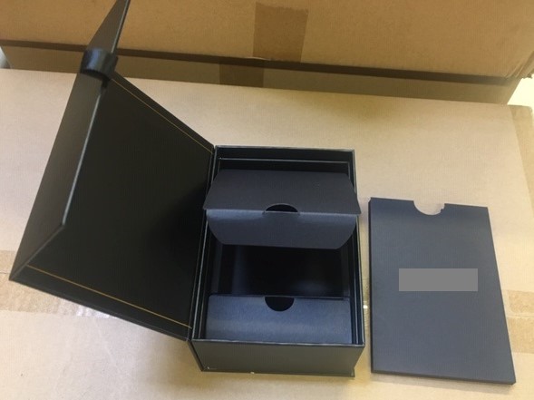Pappask med måtten 138 x 100 x 65 mm (L x B x H). Asken har ett viklock som tillsluts med magneter.
Varan är enligt uppgift avsedd att användas för att förpacka en kamera för försäljning. Asken är invändigt utformad för kameran.
Asken består enligt uppgift av papp, invändigt finns en insats av cellplast. En dokumentficka av papp (för instruktionsbok) medföljer.
Pappen ger varan dess huvudsakliga karaktär.