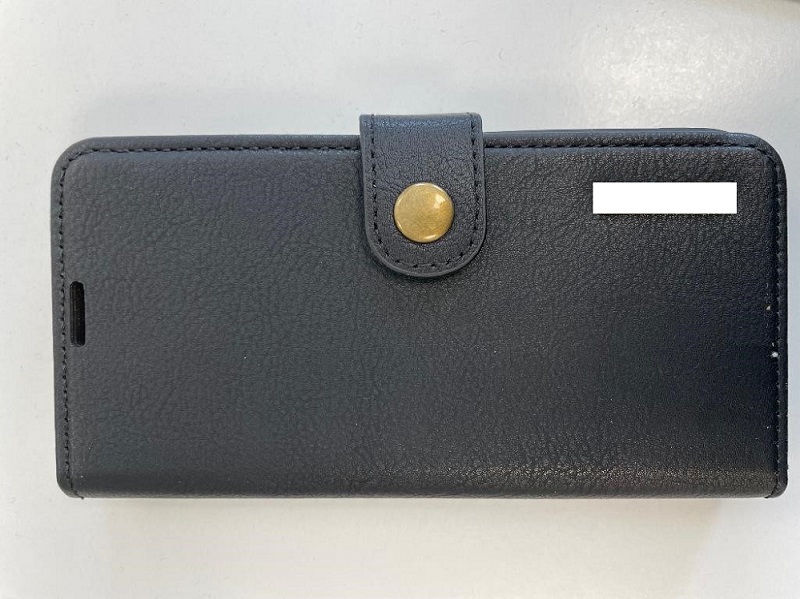 Enligt uppgift läderfodral till en mobiltelefon (s.k. smartphone) med magnetisk tillslutning i form av en magnetknapp. Fodralet har rektangulär form med rundade hörn. Fram- och baksidan har utskärningar för telefonens kameralinser. Insidan är försedd med tre slitsar för kort, en ficka för sedlar och en magnetisk, löstagbar hållare av plast som håller fast telefonen. Hållaren är försedd med utskärningar för knappar, laddkabel och dylikt. Fodralet har enligt uppgift måtten 14 x 8 x 2 cm (L x B x H).
Fodralet omsluter och skyddar telefonen genom att täcka dess baksida, sidor och framsida. Fodralet är avsett att bäras i ficka eller handväska.