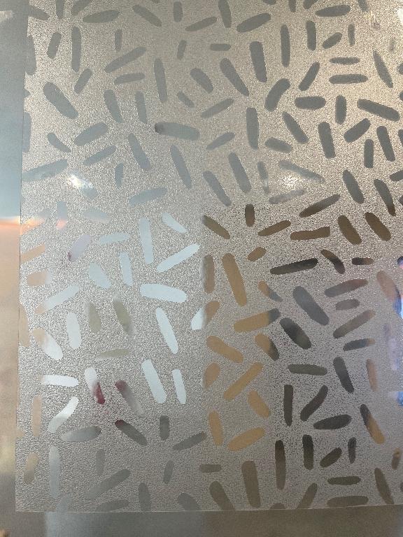 Platt, självhäftande fönsterfilm i rulle med måtten 150 x 50 cm, enligt uppgift tillverkad av plast. 

Fönsterfilmen har fyra skikt bestående av frostad beläggning (akrylharts), PET film (polyetylentereftalat), limskikt och ett avtagbart skyddande skikt. Filmen har frostad yta med transparant mönster och är avsedd att fästas på fönsterglas för att få insynsskydd. Filmen har en tjocklek av 115 (± 15) µm.

Filmen föreligger tillsammans med skrapa (rPP) och fyra självhäftande klisterlappar (används i samband med installationen). Dessa utgör tillsamman en sats för försäljning i detaljhandeln. 

Fönsterfilmen ger satsen dess huvudsaklig karaktär på grund av dess betydelse i avsedd användning.