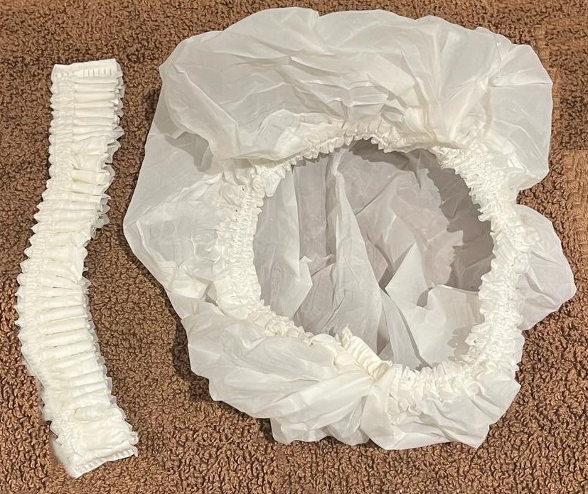 Huvudbonad enligt uppgift i form av ett konfektionerat rynkat hårskydd (duschmössa) med elastisk bård.
Varan är avsedd som hårskydd/duschmössa.
Produkten är tillverkad av nedbrytbara polymerer bestående av polybutylenadipattereftalat (PBAT), polymjölksyra (PLA) och termoplastisk stärkelse (TPS, från majskorn).
Produkten är biologiskt nedbrytbart.