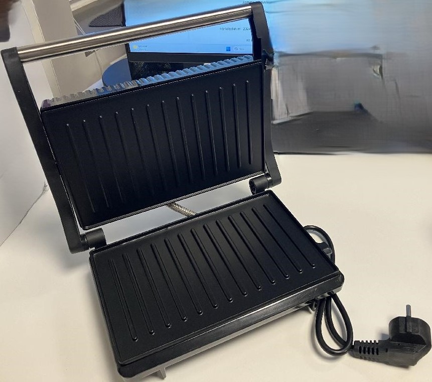 Elektrisk värmeapparat i form av en paninigrill för hushållsbruk med en effekt av 750 W.
Varan är avsedd att användas för att grilla smörgåsar, grönsaker och kött mm.
Paninigrillen har enligt uppgift utsida av rostfritt stål och plast (bakelit), räfflade värmeplattor av aluminium med non-stick beläggning och måtten 26 x 22 x 9 cm (B x L x H).
Paninigrillen är förpackad för försäljning i detaljhandeln.