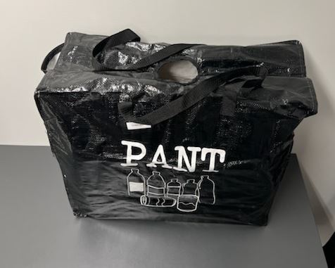 Väska med lock avsedd för långvarig användning.
Väskan ska användas för förvaring och transport av flaskor och burkar för återvinning.
Väskan är tillverkad av tvåskaftsbunden väv bestående av remsor av plast (enligt uppgift polypropen) med en bredd mindre än 5 mm. Väskans utsida är belagd med plast synlig med blotta ögat och försedd med tryck. Väskan är konfektionerad genom sömnad, har två vävda bärhandtag av textilmaterial fastsydda på långsidorna, är ofodrad och saknar invändiga fack. Locket tillsluts med dragkedja och är försett med ett bandkantat runt hål (ca 10 cm i diameter).
Väskan har måtten ca. 58 x 60 x 23 cm (B x H x D).