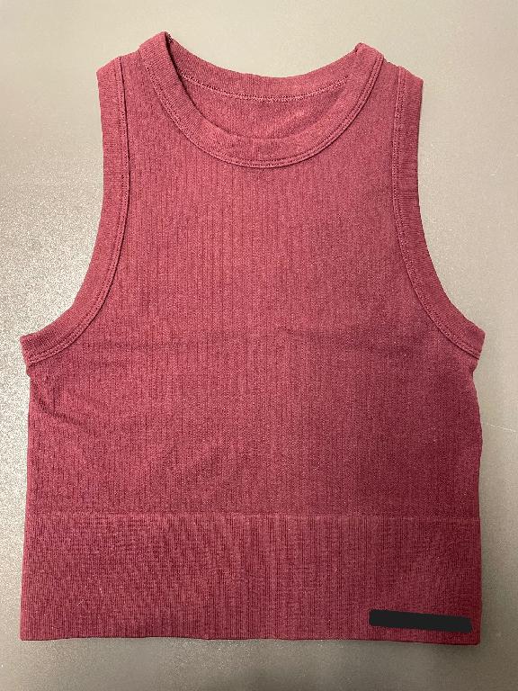 Åtsittande ärmlöst klädesplagg för överdelen av kroppen, s.k. ”crop top”. Klädesplagget når ner till strax över midjan (har en längd mitt bak om ca 39,5 cm i storlek S). Plaggets halsringning och ärmhål är bandkantade. Nederkanten är försedd med resår.
Plagget är konfektionerat genom sömnad och är tillverkat av dukvara av trikå, enligt uppgift bestående av 92 % nylon och 8 % elastan.
Plagget förekommer i storlekarna S-XL.