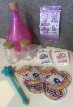 Leksakssats bestående av flera delar placerade inuti en plastflaska (PP) med plastkork (PVC).
Flaskan (försedd med etikett) öppnas och basen används som en skål för att göra en s.k. trolldryck genom att blanda de medföljande ingredienserna med staven av plast (ABS). Flaskan förekommer i olika färger. Varan används för att roa barn.
Leksakssatsen innehåller enligt uppgift:
•	en kladdig bas (Fluffy Slime Powder) och en pulverformig bas (DIY Powder) förpackade i varsin påse tillverkad av koppar, aluminium och plast (PE) med en bild av en enhörning utanpå,
•	sex olika tillbehör förpackade i påsar (MAGIC POTIONS) tillverkade av papper och plast (PE),
•	två förvaringsflaskor av plast (PP) med plastkork (PVC) och
•	en bruksanvisning (recept).
 
De båda basmaterialen består till mer än hälften av guargummi. De sex tillbehören består av plastskum (EPS), plasttabletter (PVC), färgade plastpärlor (PET) och färgade pärlor av kisel (silica).
Leksakssatsen är förpackad för försäljning i detaljhandeln i en tvådelad, återförslutningsbar plastflaska.