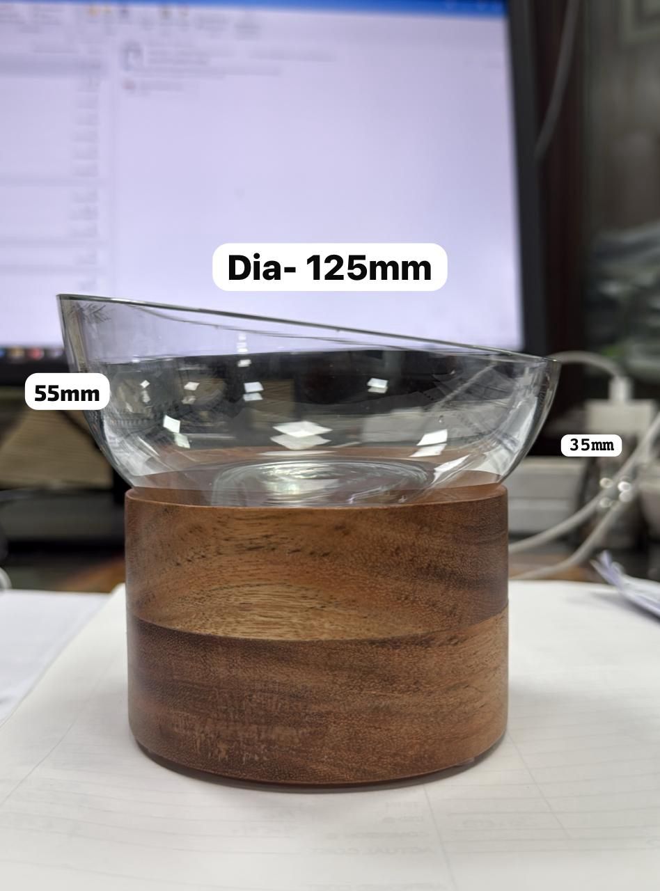 Glasvara i form av en matskål för husdjur (främst katter) bestående av skål av glas och bas av trä.
Varan placeras på marken eller golvet och är avsedd att användas för att utfodra katter.
Glasskålen är enligt uppgift handblåst av återvunnet glas, har en diameter av 12,5 cm, höjd i framkant 3,5 cm och höjd i bakkant 5,5 cm. Basen är enligt uppgift tillverkad av acaciaträ (FSC), har en diameter av 9,5 cm och en höjd av 5,5 cm.
Matskålen av glas ger varan dess karaktär.