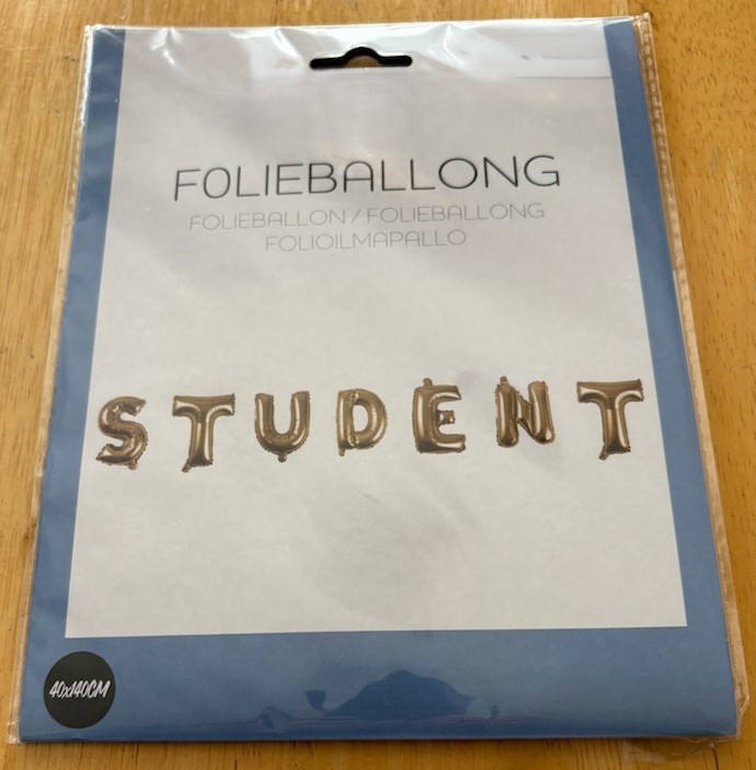 Set med sju folieballonger i form av bokstäver som bildar ordet "STUDENT".
Ballongerna ska användas vid studentfirande.
Folieballongerna är enligt uppgift tillverkade av aluminiserad plastfolie, har en höjd av ca 40 cm och fylls med luft eller helium via ett medföljande rör av papp, ca 12 cm långt. Upphängningsband med en bredd av ca 0,4 cm medföljer. Enligt uppgift på förpackningen mäter varan 40 x 140 cm.
Varan är förpackad för försäljning i detaljhandeln. Ballongerna ger varan dess huvudsakliga karaktär.